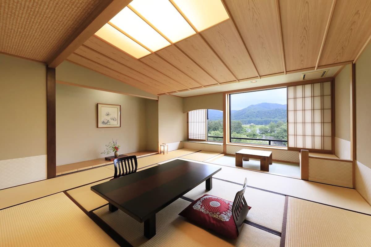 A traditional Japanese room with tatami flooring, a low table, and sliding shoji doors.