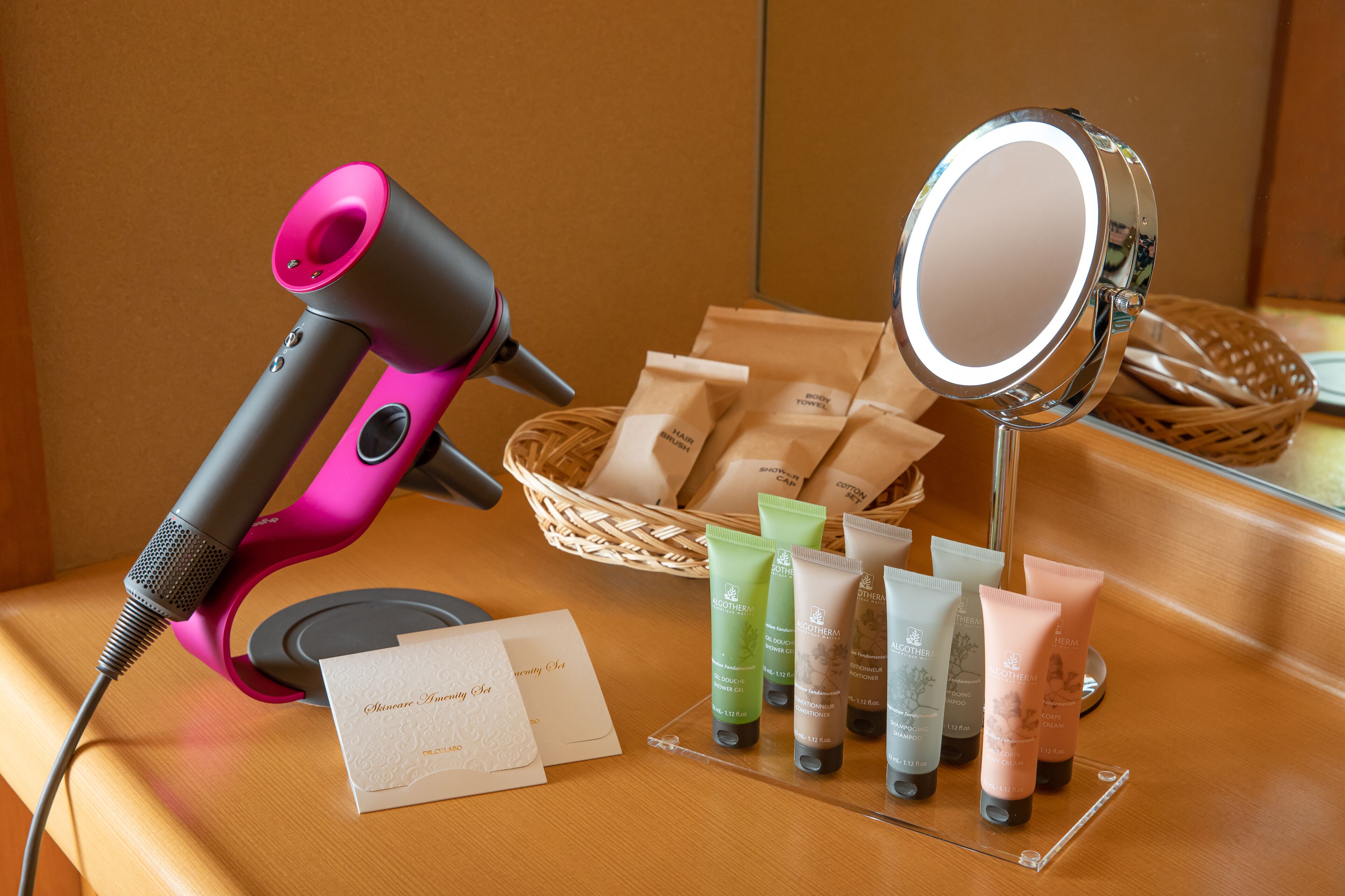 Een haardroger, een spiegel en diverse haarverzorgingsproducten op een houten oppervlak.