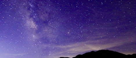 A night sky filled with stars and the Milky Way over a mountain range.