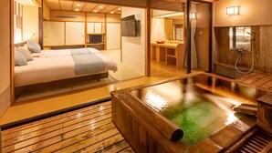 A traditional Japanese-style room with a tatami mat floor, a tatami mat bed, a wooden washbasin, and a wooden bathtub. - Hotel Keisui (Omachi)