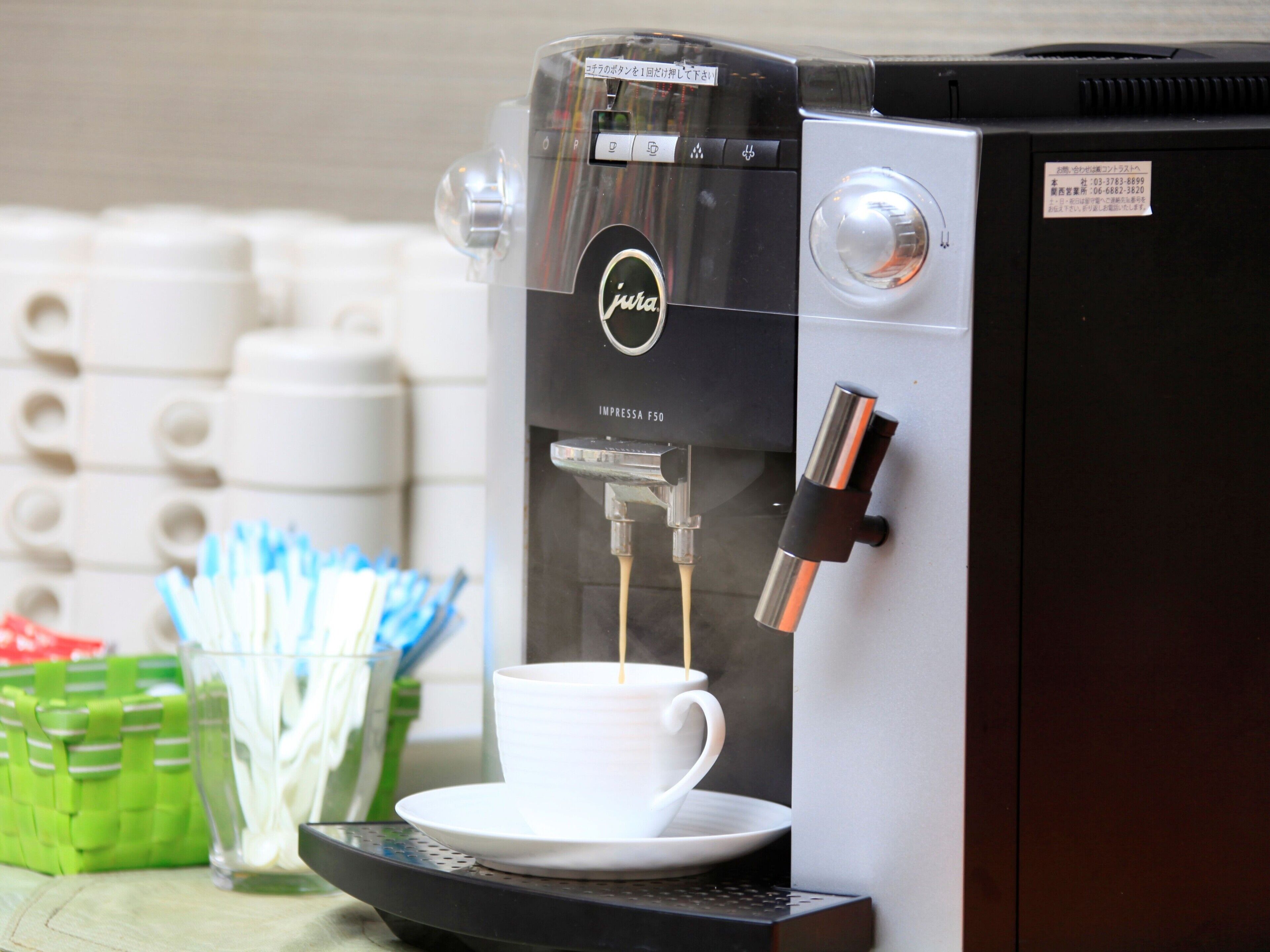 A coffee machine with a cup of coffee being dispensed.