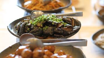 A buffet table with various dishes, including seafood and meat, arranged in metal serving dishes.