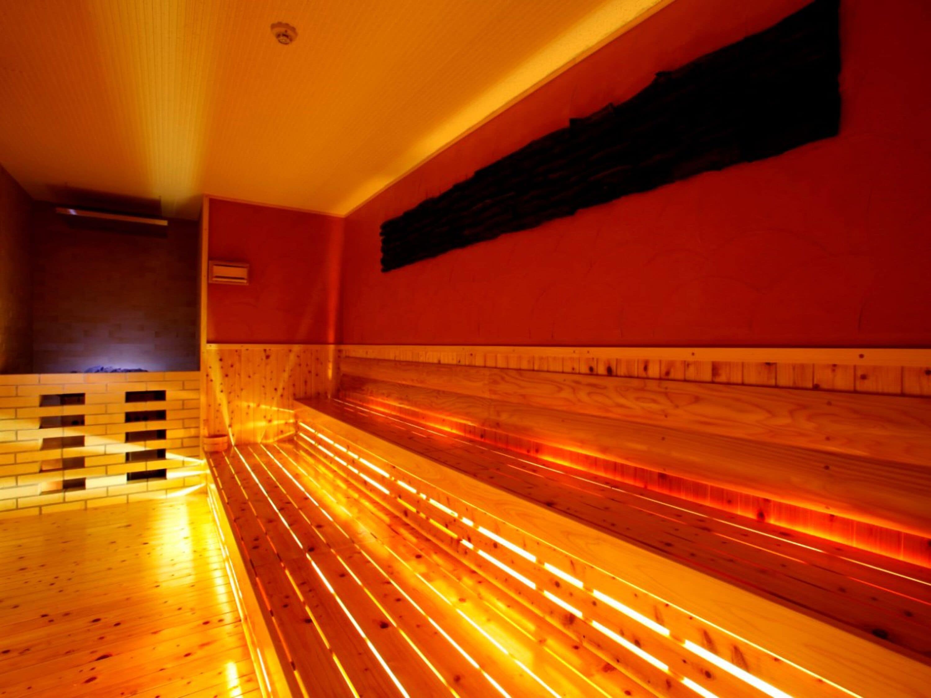 A sauna with wooden benches and a tiled floor.