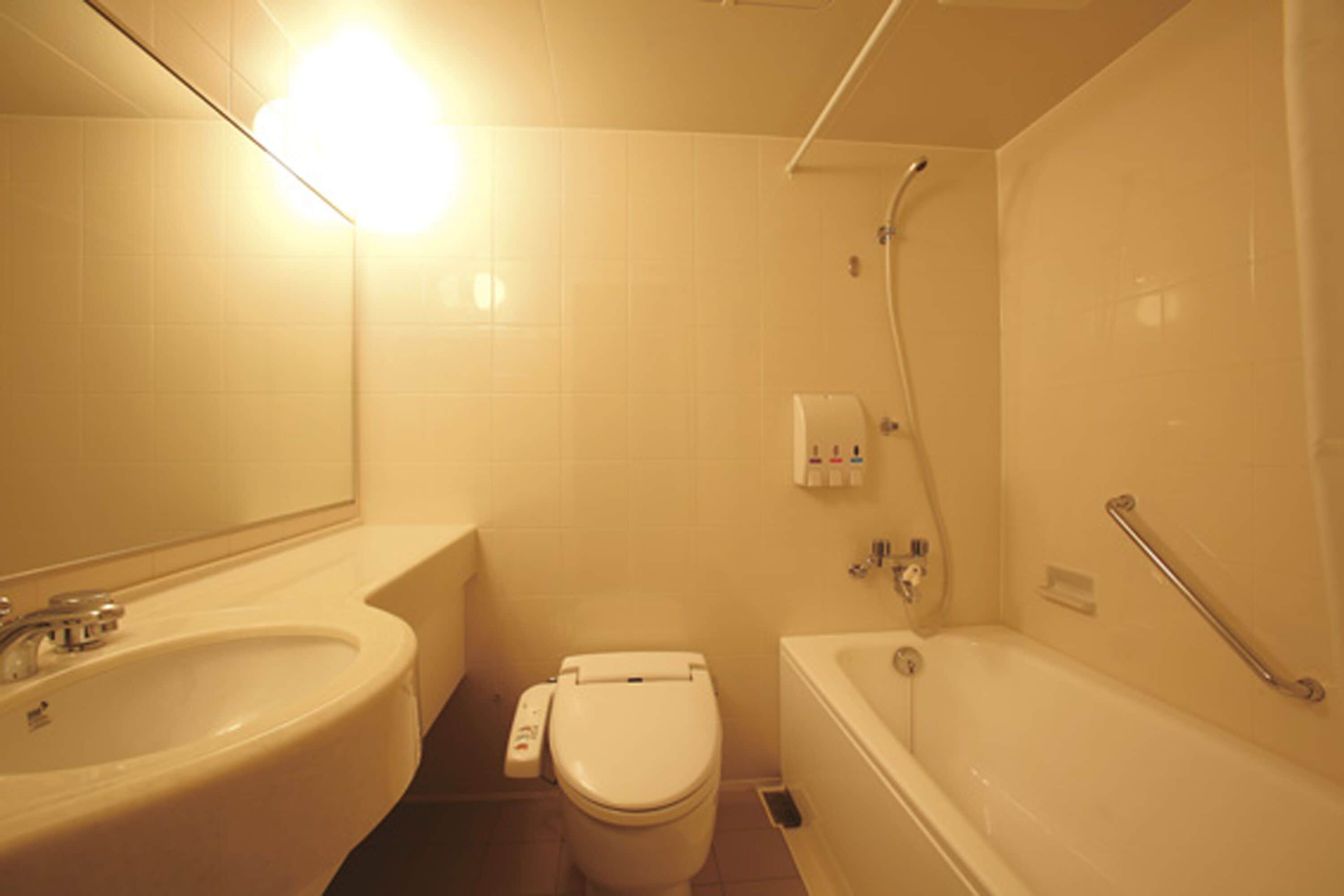 Een badkamer met wastafel, toilet en bad.