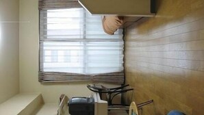 A room with a window, a chair, a small table, and a radiator. - Benefit Hotel Okayama 1 (Okayama)