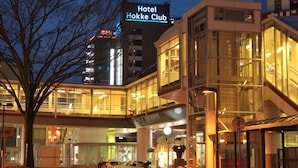 A modern hotel building with a prominent sign for Hotel Hokkek Club.