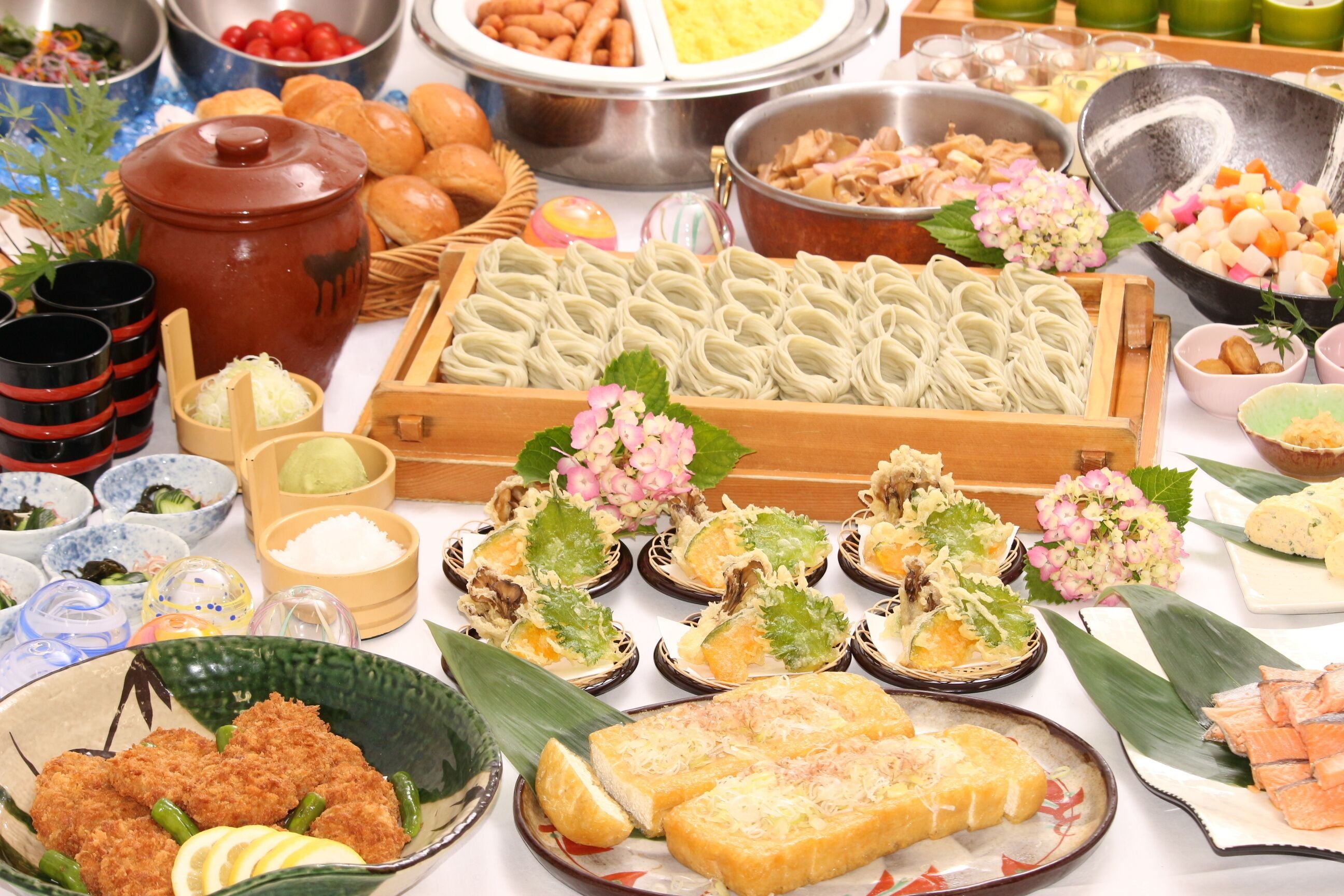 A variety of food items including dumplings, fried items, and a selection of vegetables and fruits.
