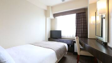 A hotel room with a bed, a desk, a chair, a television, and a large mirror.