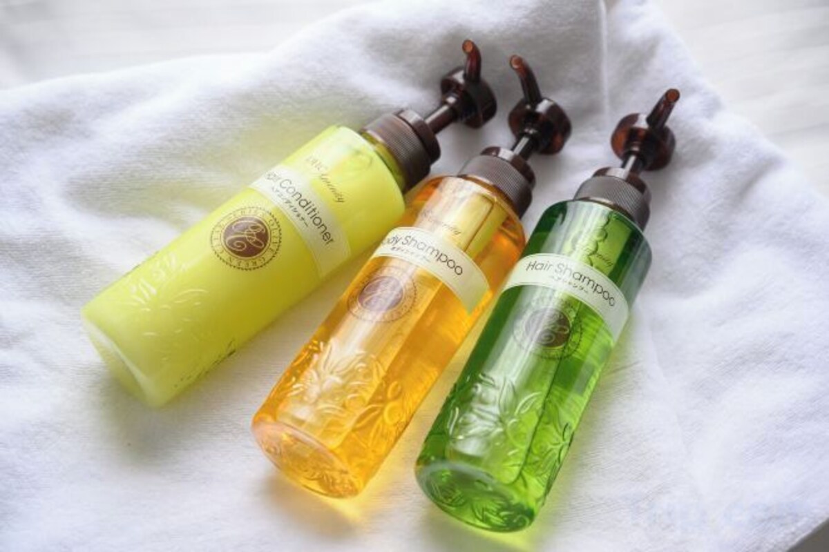 Three bottles of hair care products on a white cloth.