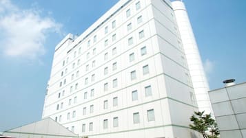 A multi-story hotel with a modern design, featuring a large central tower and a symmetrical facade with evenly spaced windows.