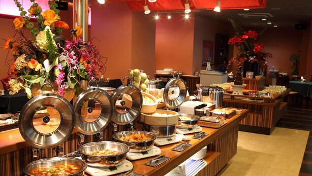A buffet setup with various food items and a floral centerpiece. - King Ambassador Hotel Kumagaya (Kumagaya)