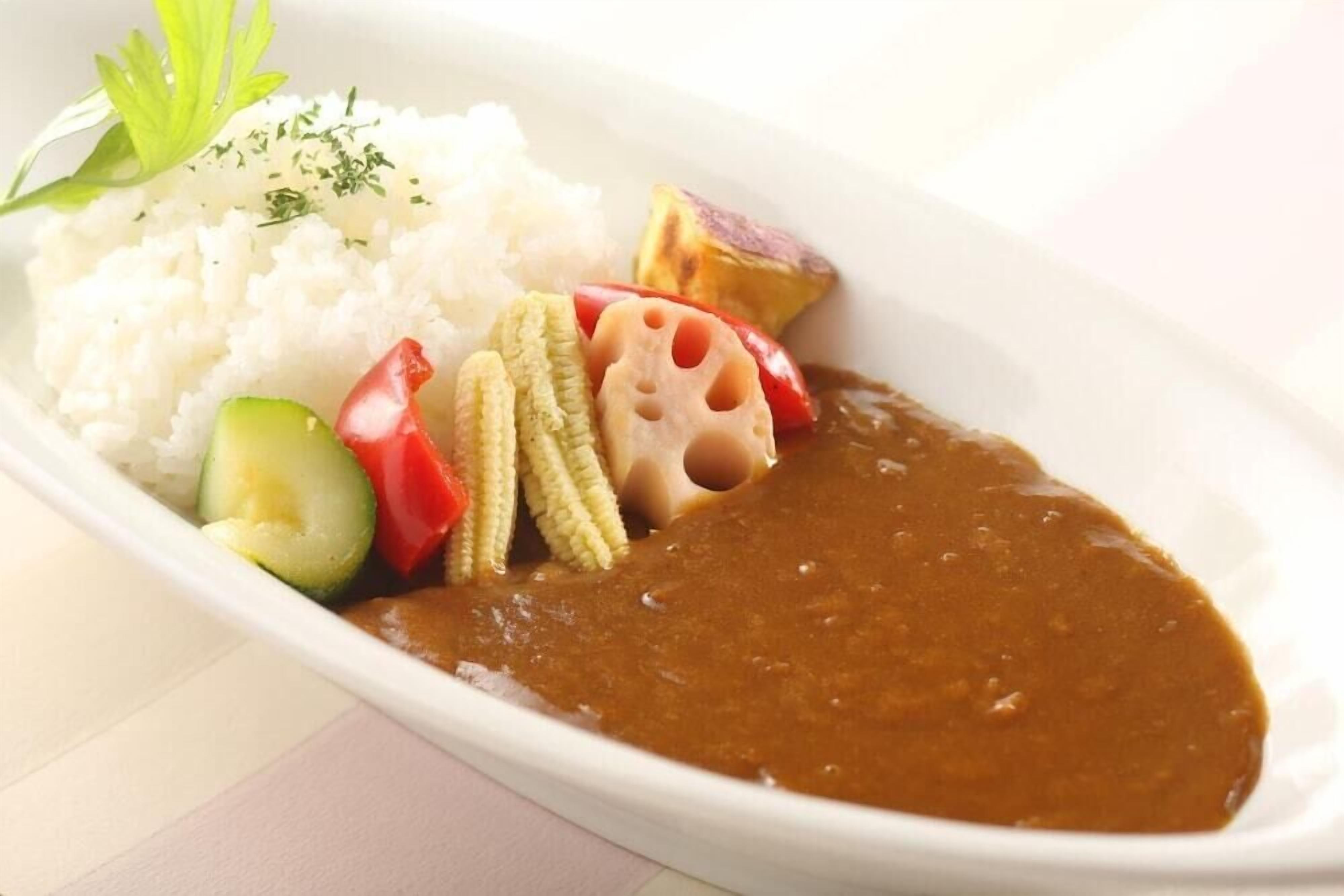 A plate of food with rice, vegetables, and a brown sauce.