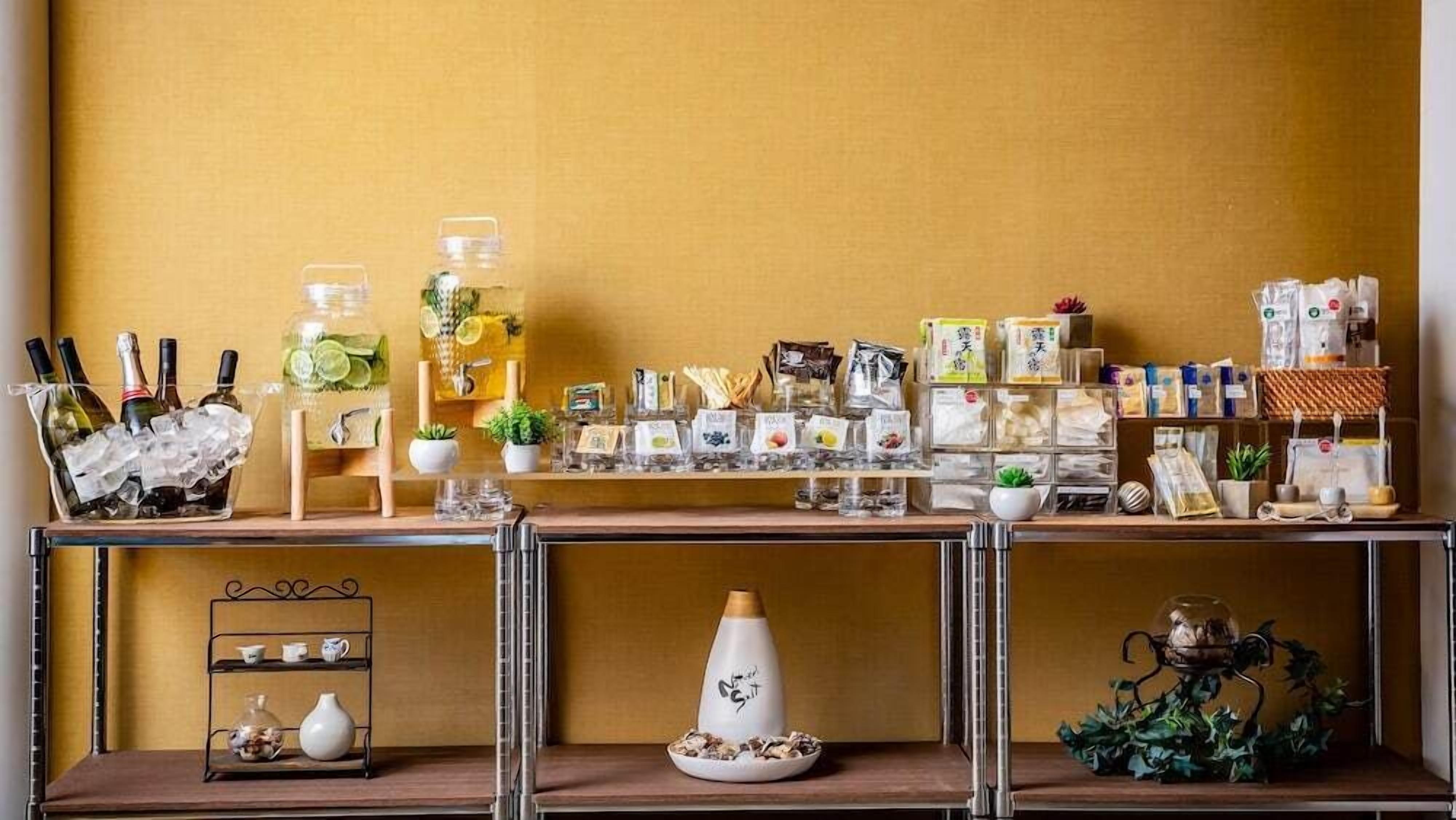 Une présentation soignée de divers articles, notamment des bouteilles, des récipients et des produits emballés, disposés sur des étagères devant un mur jaune.