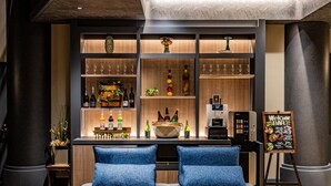 Una zona de bar con estantes llenos de botellas y vasos, una máquina de café y un menú en una pizarra.