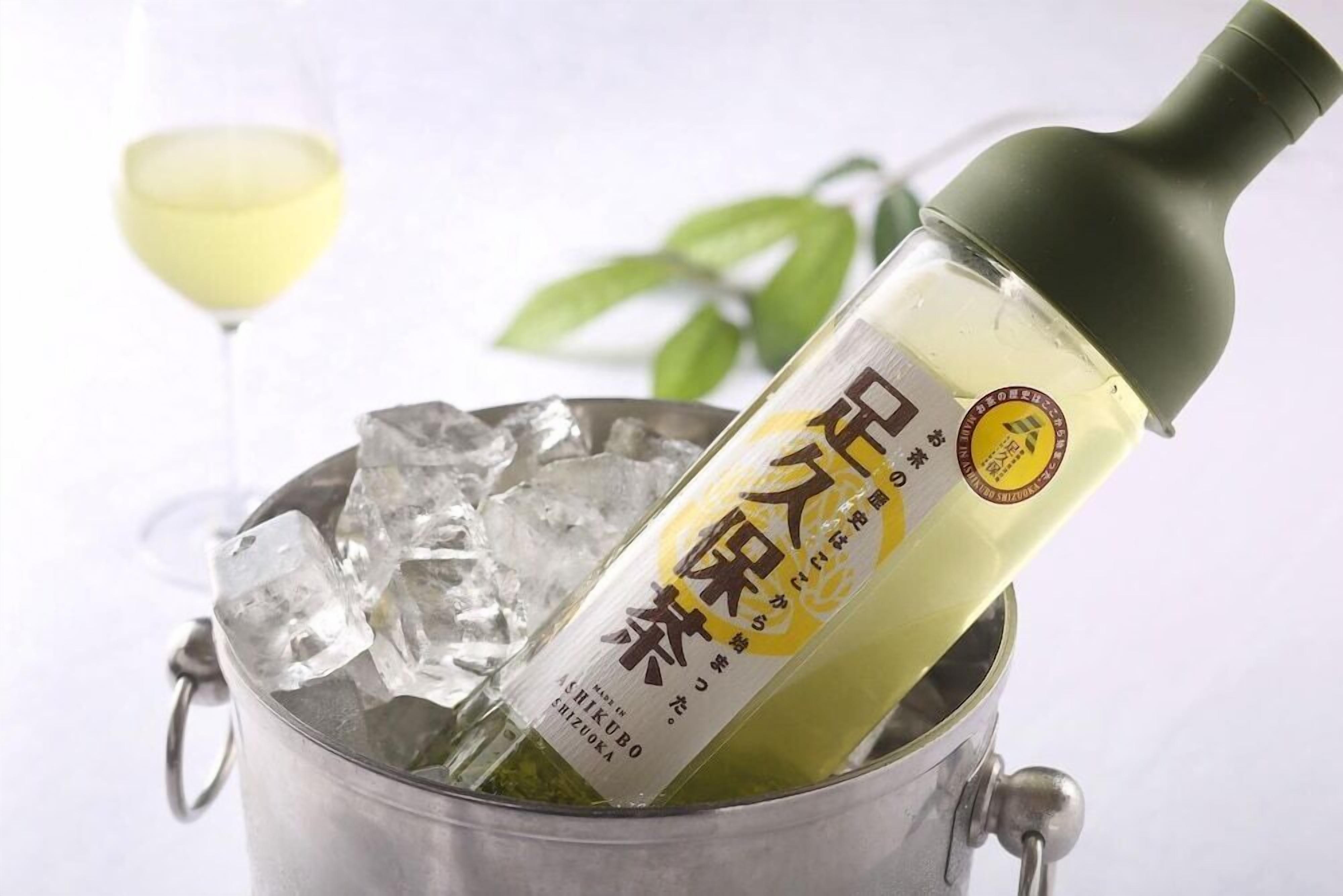 A bottle of sake in a metal bucket with ice cubes.