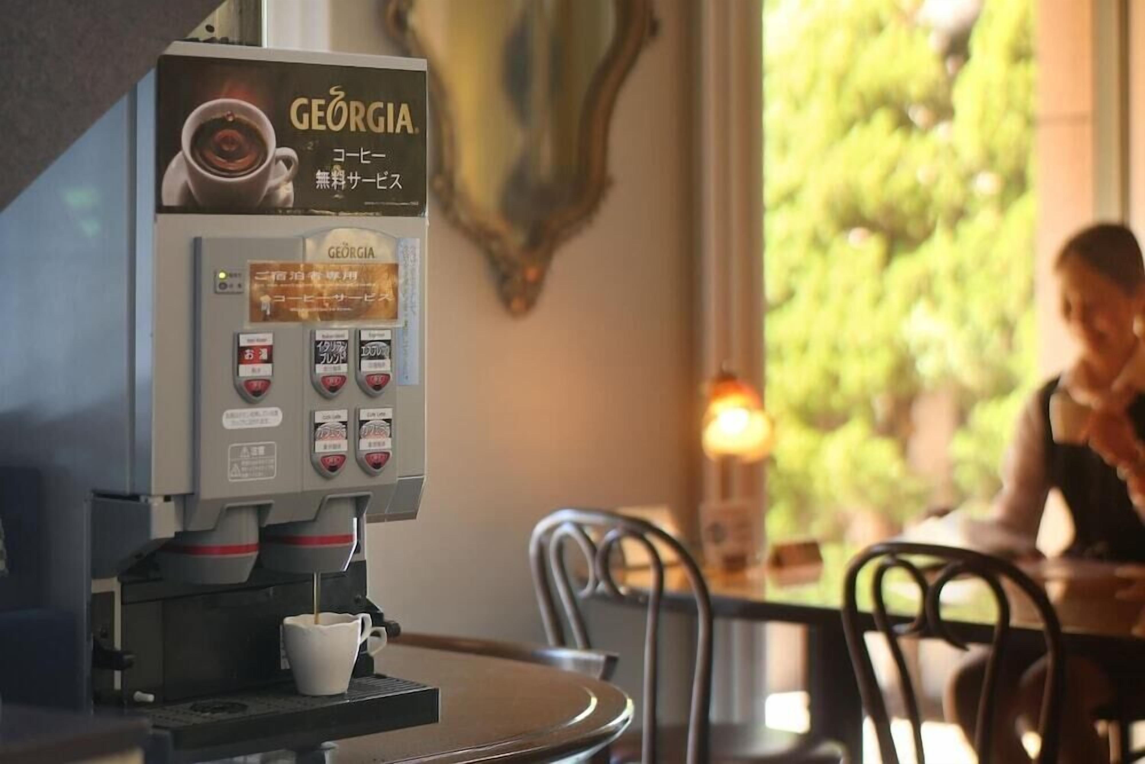 A coffee machine with multiple drink options and a cup placed on the counter.