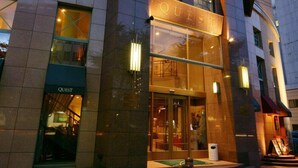 Un edificio con un letrero que dice "QUEST" sobre la entrada.
