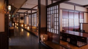 A traditional Japanese-style interior with tatami flooring, sliding doors, and a reception area with a wooden desk and chairs. - Nukumori no Yado Furukawa (Sapporo)