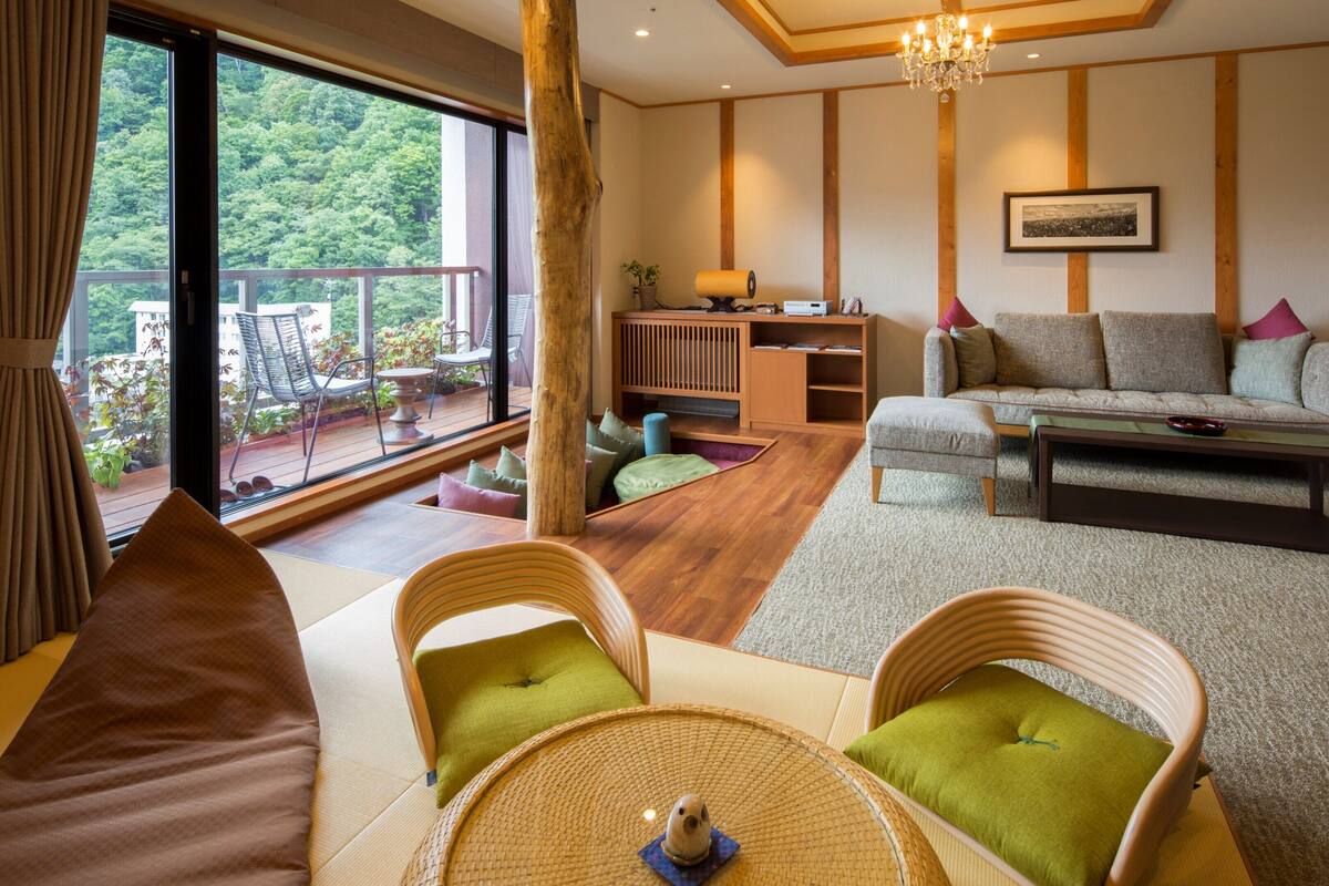 A spacious living room with a sofa, chairs, a coffee table, and a view of the outdoors.