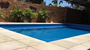 Alberca al aire libre y camastros