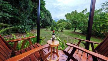 Relax on the deck surrounded by lush greenery, with a bottle of wine and two glasses at your fingertips.
