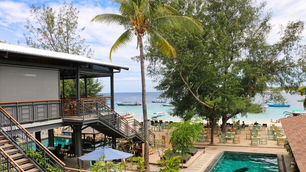 A resort with a pool, outdoor seating, and a view of the sea. - Trawangan Dive Centre (Gili Trawangan)