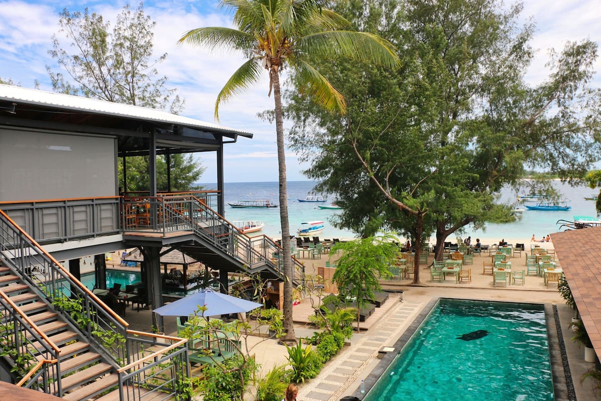 Ein Resort mit Pool, Sitzgelegenheiten im Freien und Meerblick.