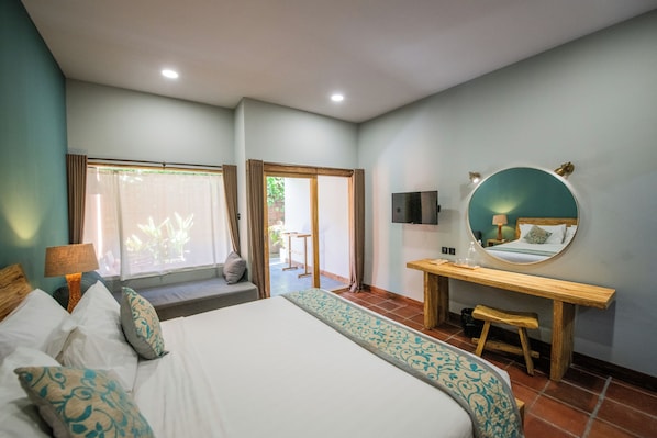 A hotel room with a large bed, a desk, a mirror, and a view of the outside. - Trawangan Dive Centre (Gili Trawangan)