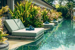 A poolside area with lounge chairs and lush greenery. - Trawangan Dive Centre (Gili Trawangan)