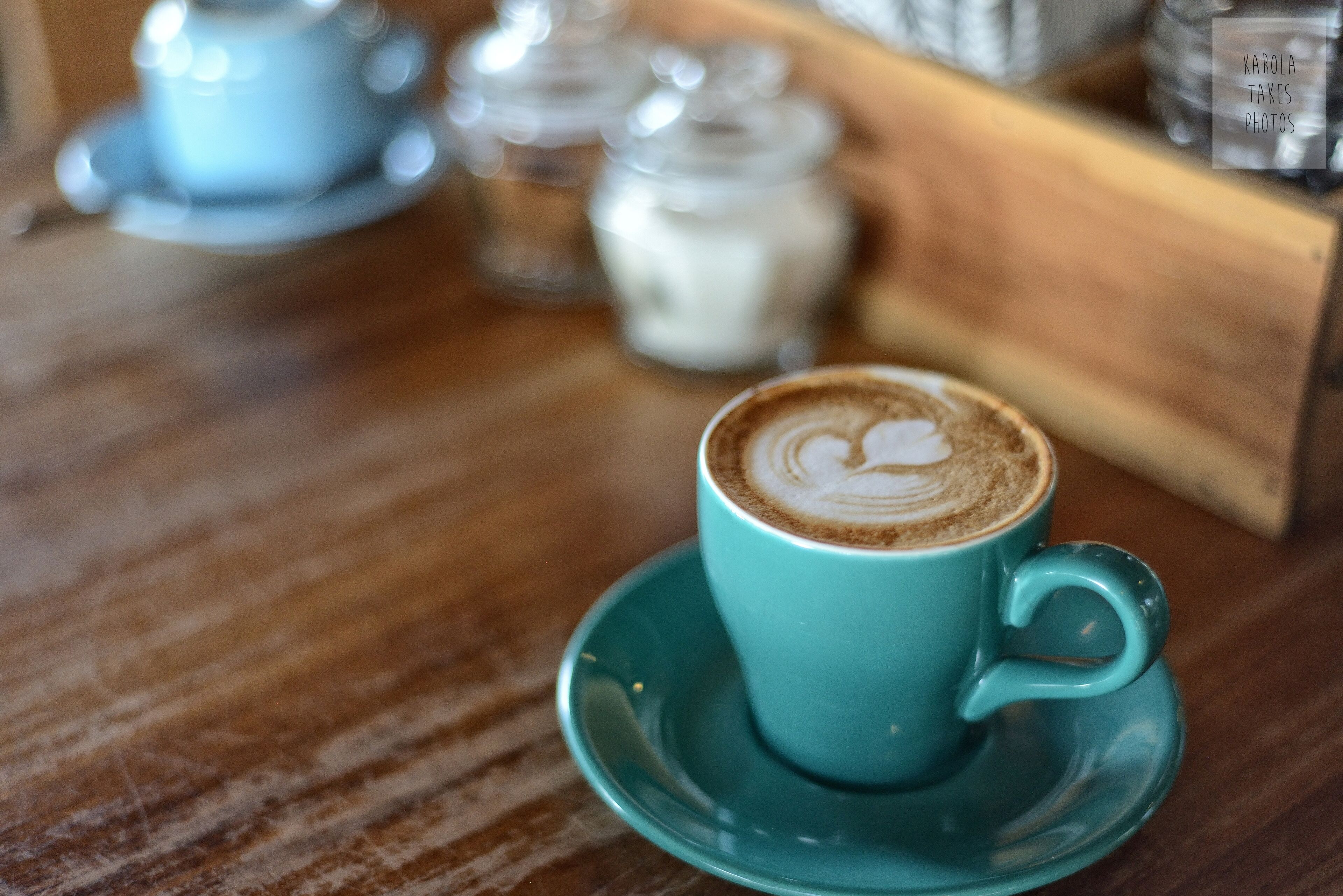 Una taza de café con leche y arte de café con leche sobre una mesa de madera.