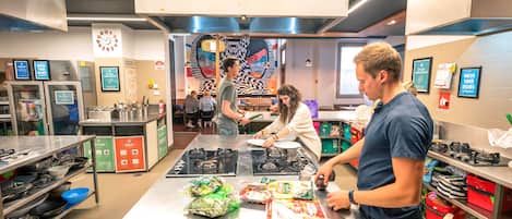 Una cocina moderna con electrodomésticos de acero inoxidable, una isla central con alimentos y un reloj en la pared.