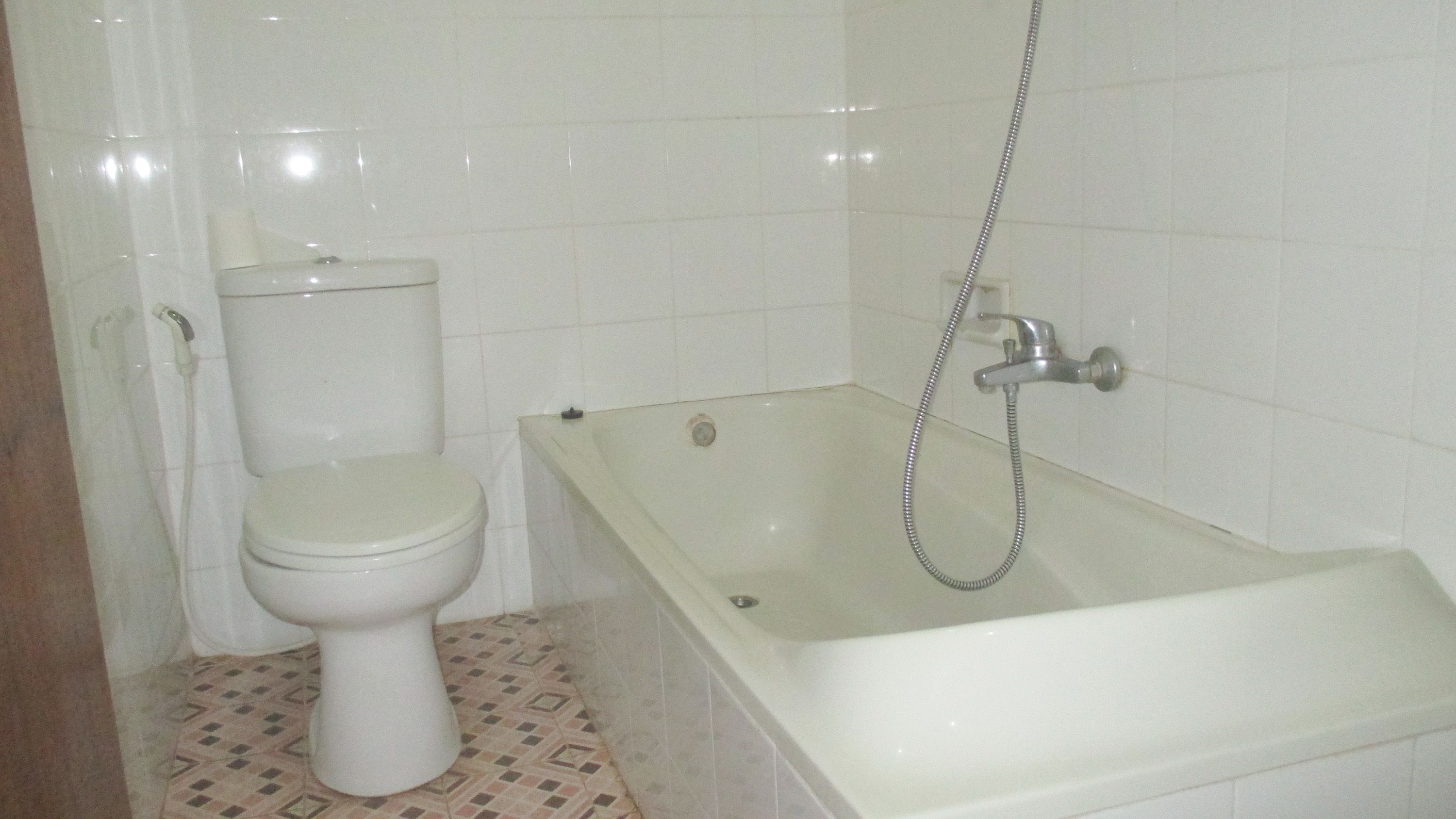 A bathroom with a toilet, a bathtub, and a shower.