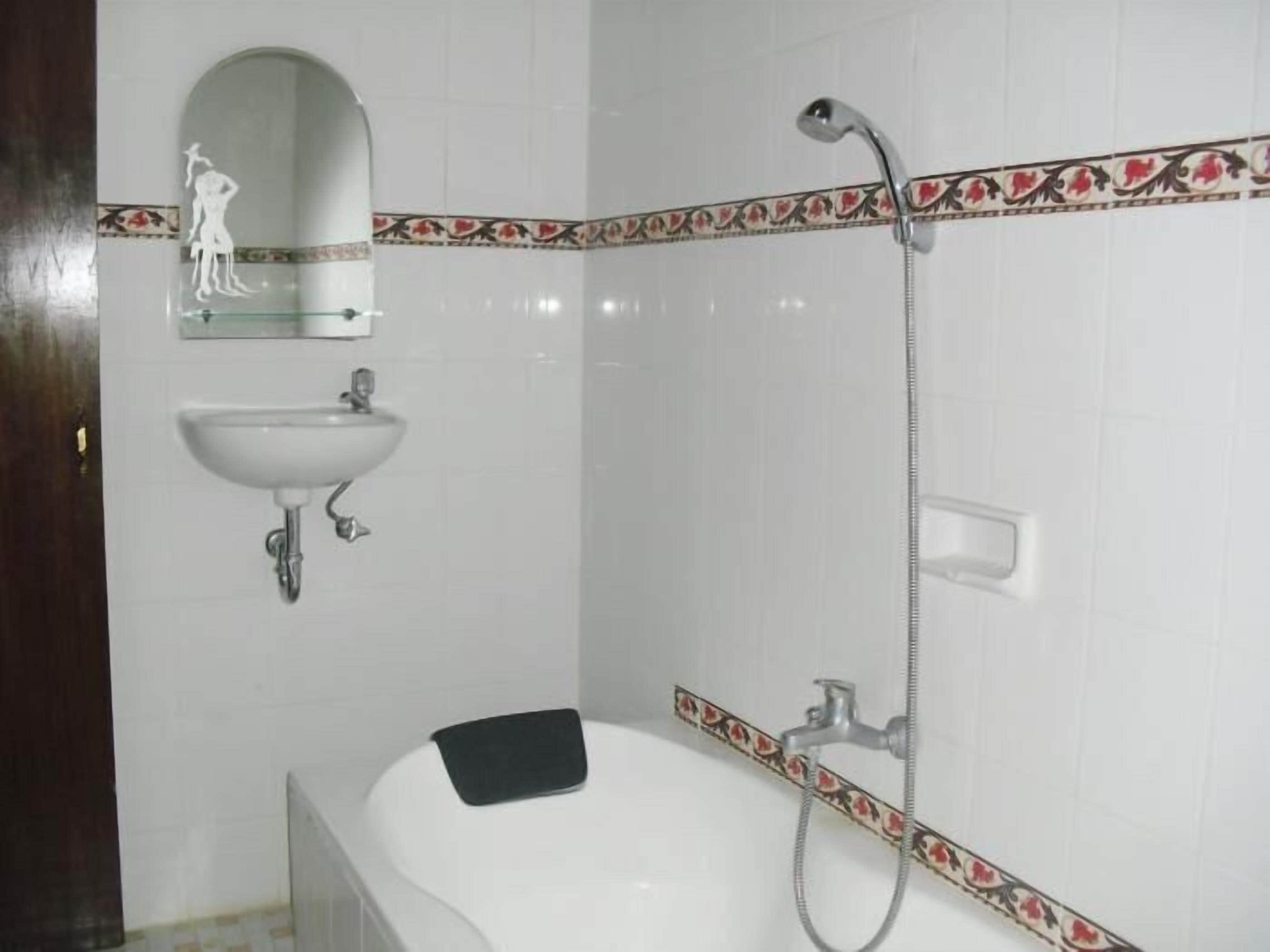 A bathroom with a bathtub, a sink, and a shower.