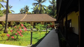 A building with a tiled roof and a pathway leading to it. - Trawangan Oasis (Gili Trawangan)
