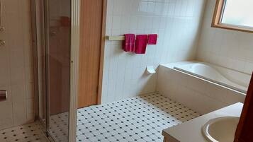 Un baño con ducha, inodoro y lavabo.