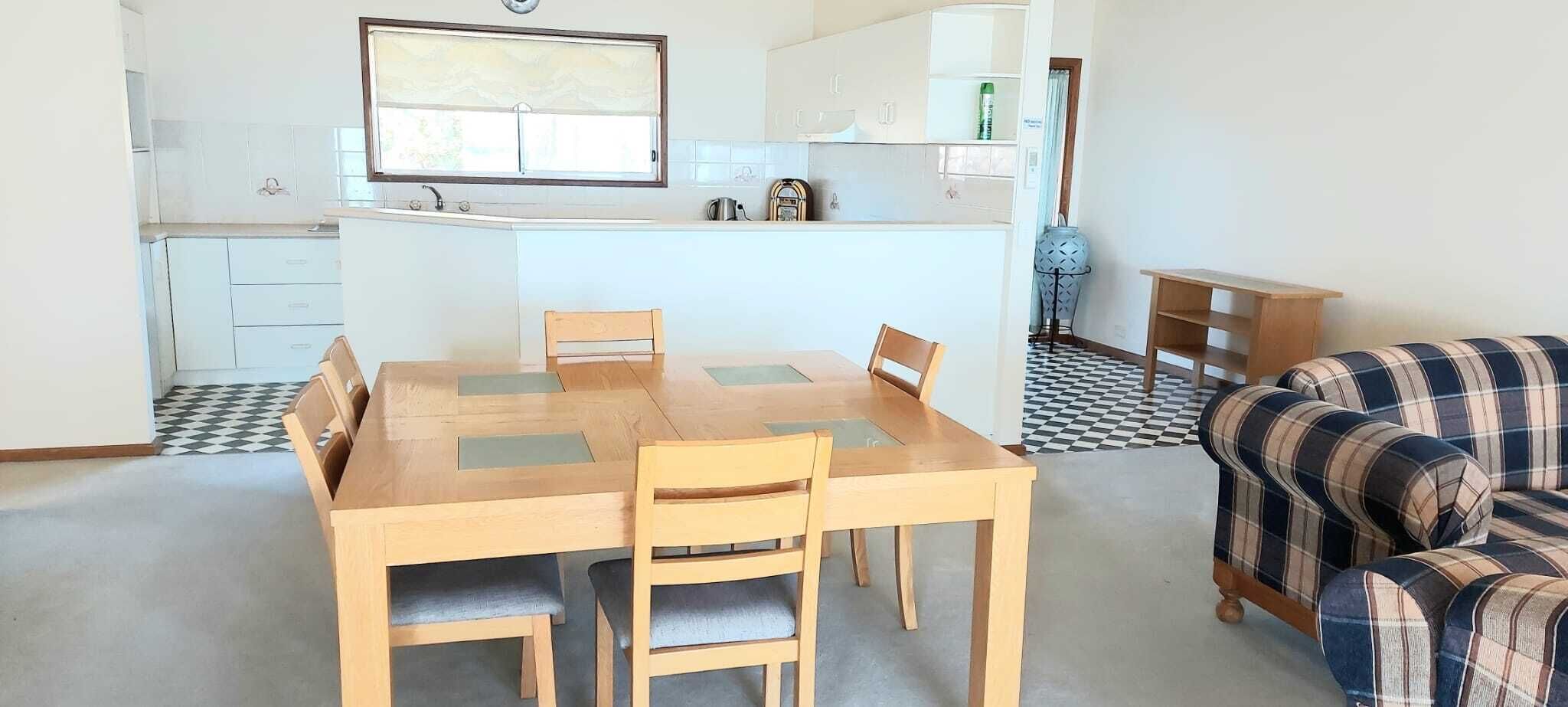 Un espacio habitable compacto con comedor, kitchenette y sofá.