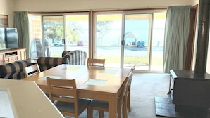 A living room with a sofa set, a dining table, and a TV. - Barmera Lake Resort Motel (Barmera)