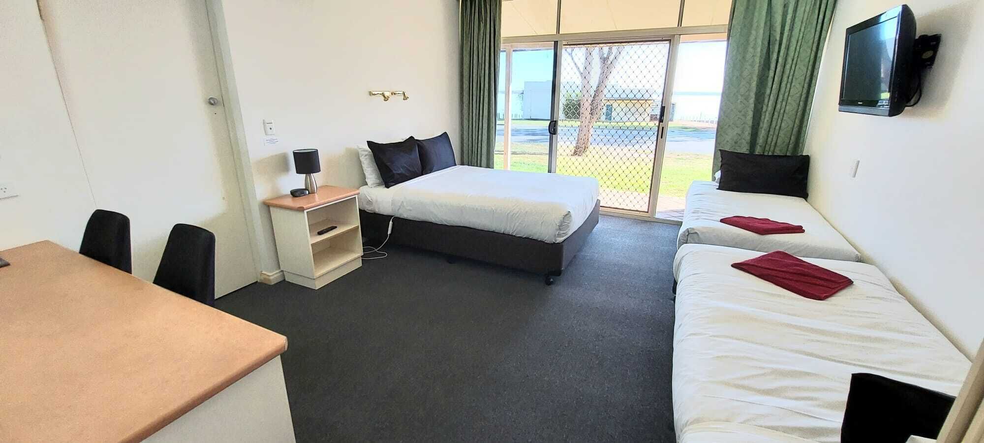 Una habitación de hotel con cama, escritorio y televisión.