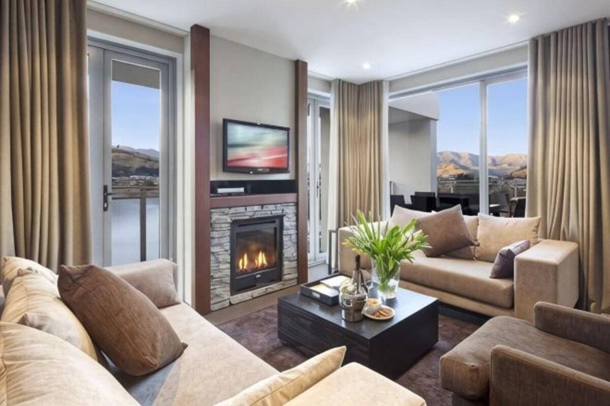 Una sala de estar con chimenea, televisor y sofá.
