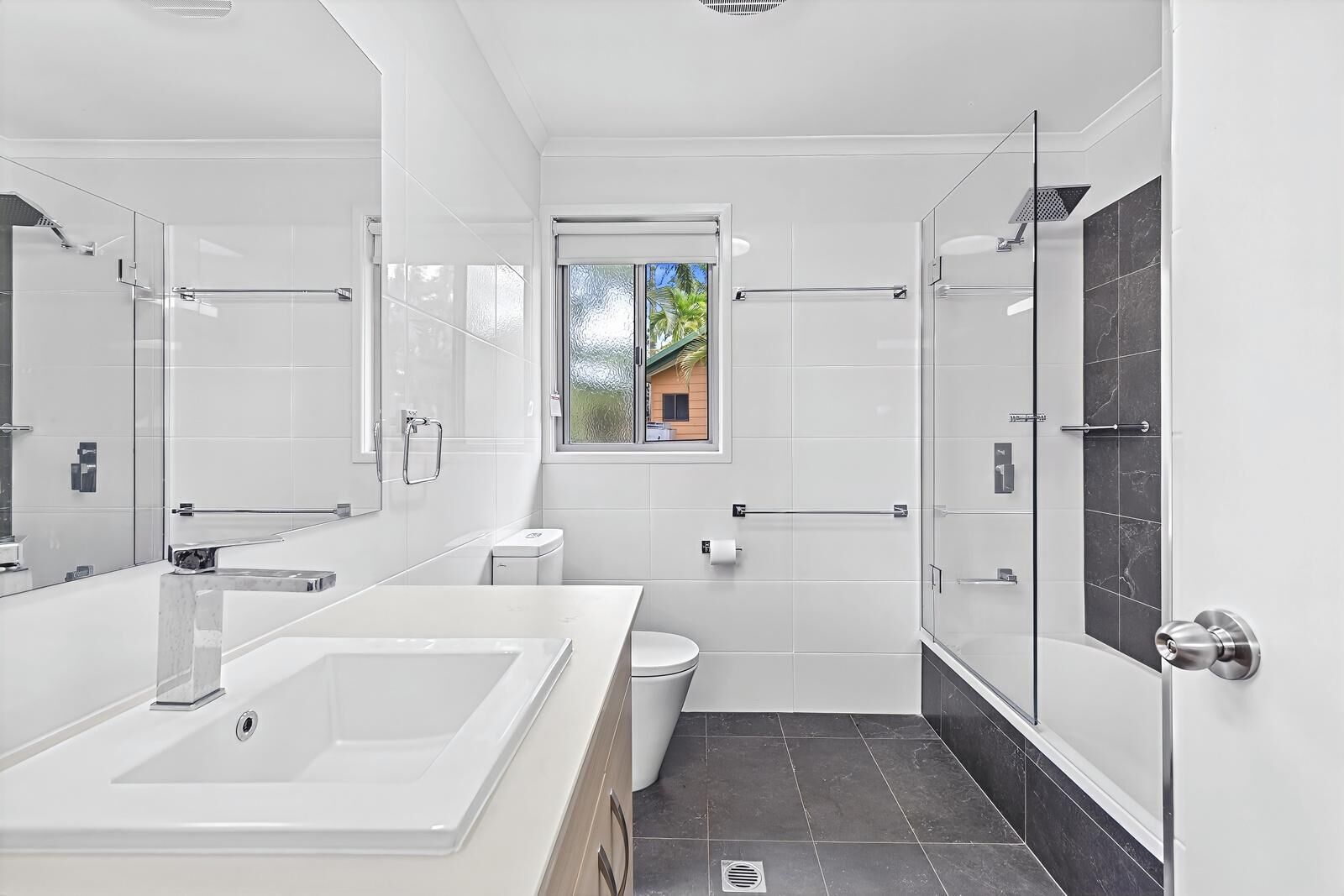 A modern bathroom with a large bathtub, a toilet, and a shower area.