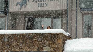 A building with a sign reading "SQUATTER'S RUN" and a stone wall in front.