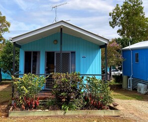 Un petit bâtiment d’un seul étage, à l’extérieur bleu, doté d’un porche et d’une enseigne portant le numéro « 213 ».