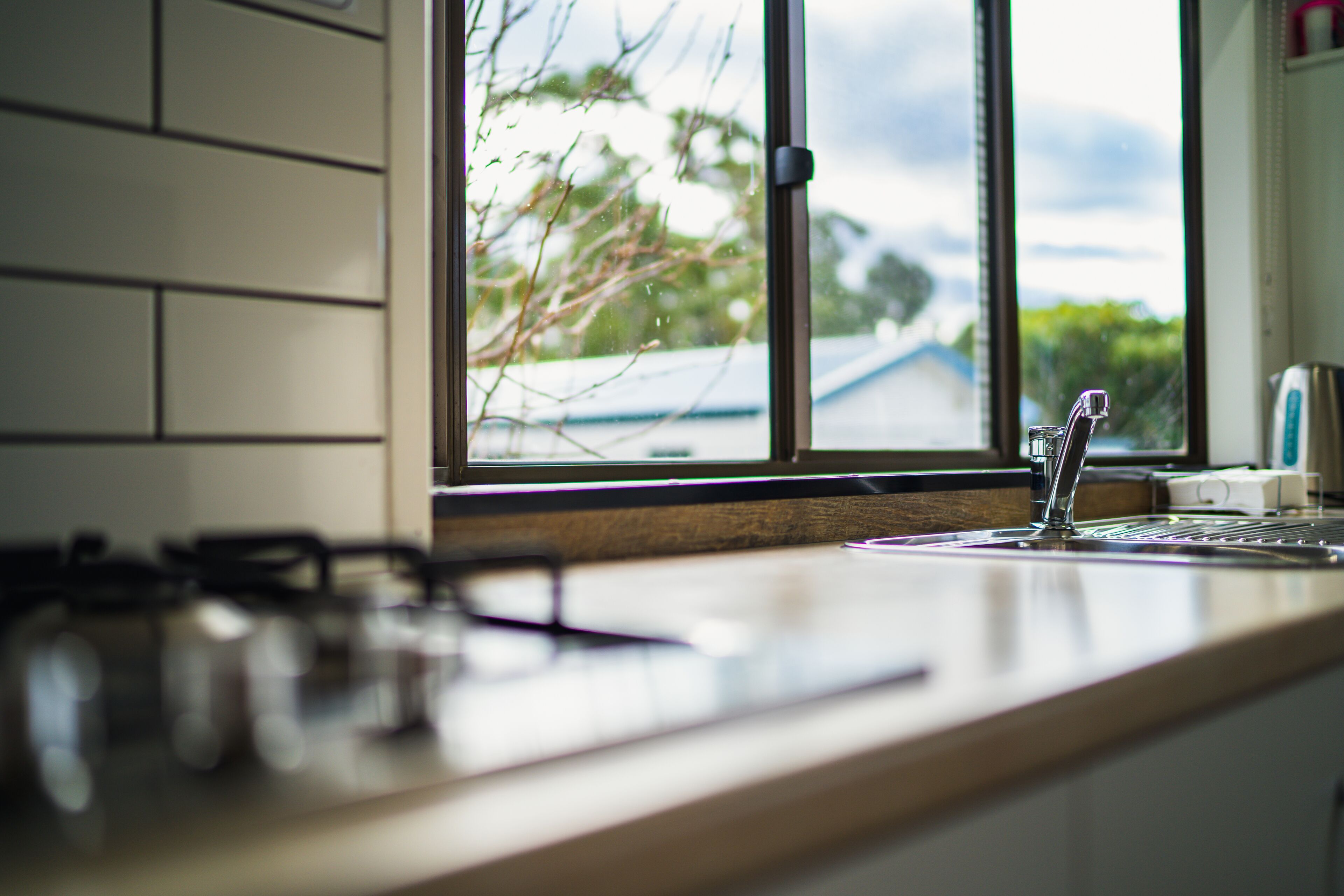 A kitchen with a window, a gas stove, and a sink.