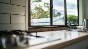 A kitchen with a window, a gas stove, and a sink.