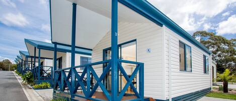 A row of mobile homes with blue railings and a covered porch area.