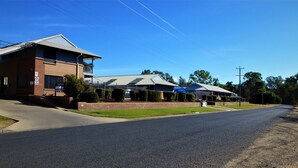 A two-story building with a flat roof, a balcony, and a sign indicating a 5 area. - Albert Motel (Moree)