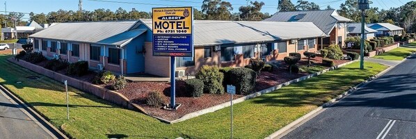 A motel with a signboard advertising internet facilities, spa rooms, air conditioning, and direct dial phones.
