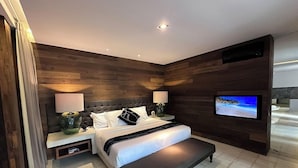 A modern bedroom with a bed, bedside tables, a TV, and a bench.