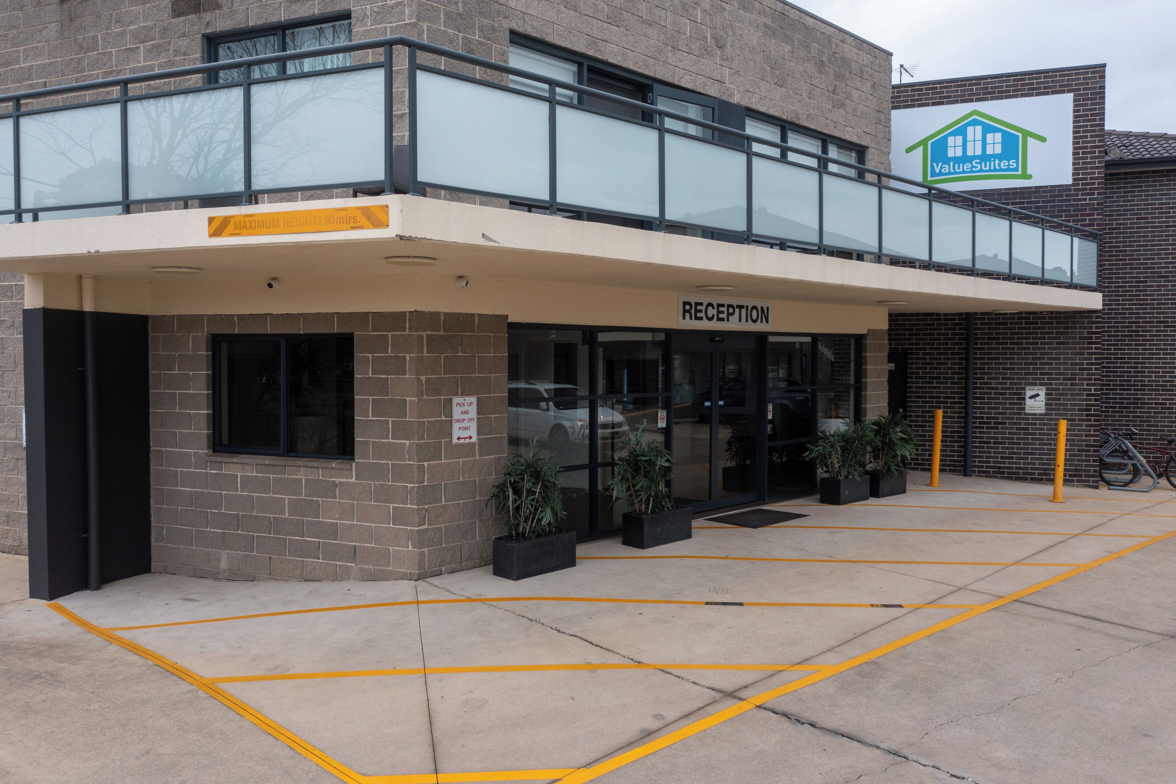 A building with a reception area, a sign for ValueSuites, and a parking lot with yellow lines.