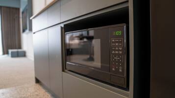 A modern kitchen with a built-in microwave and oven, featuring a digital display and control panel.
